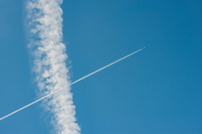 a contrail flies across the sky behind a jet