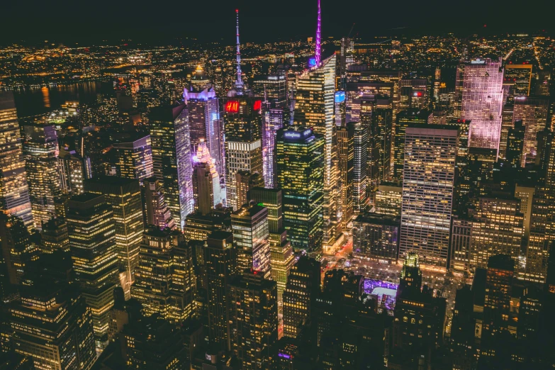 a city skyline at night, lit up with red and blue