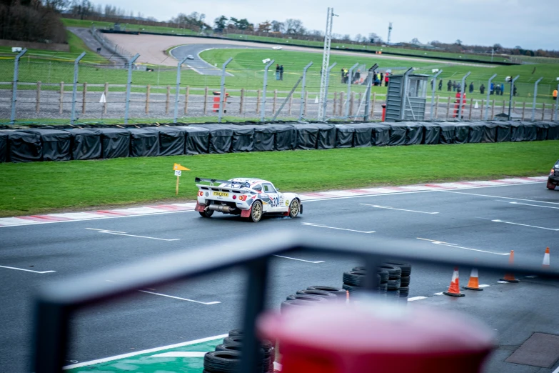 race car driving on track during competition in open grassy area