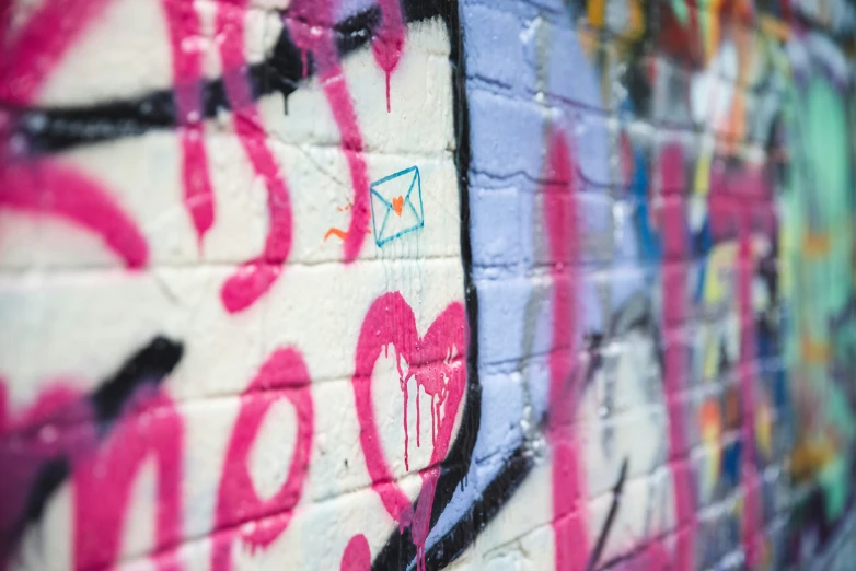 some wall with various colored graffiti on it