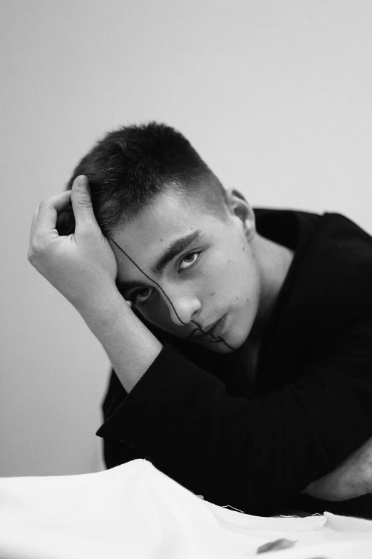 a man sitting in bed wearing a black shirt