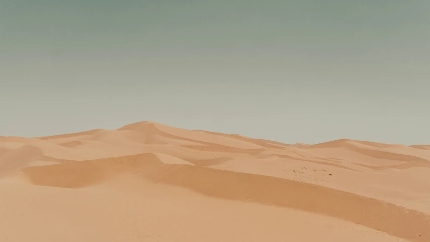 the desert landscape with a few hills and sand
