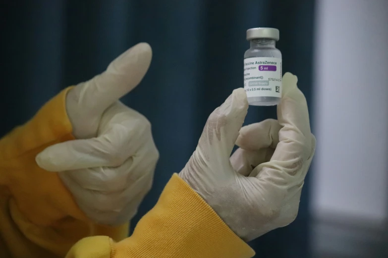 a person holds a bottle of medicine in front of their face