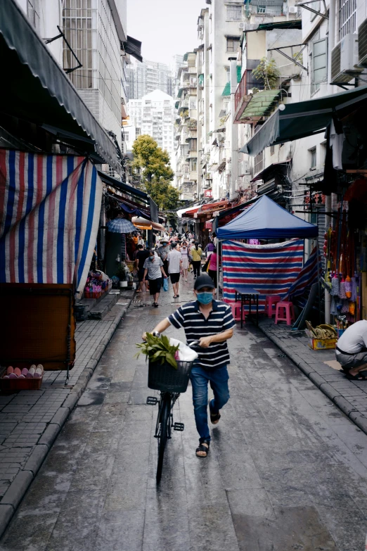 a man hing a bike with a basket full of food on the front of it