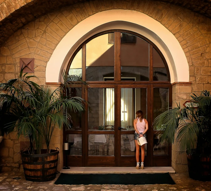 a woman in a short dress is standing at the entrance of an empty building