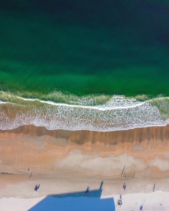 a large beach with some people walking along it