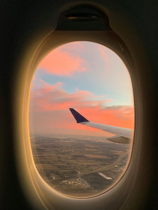 the view from an airplane window at sunset