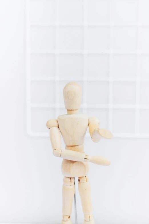 a wood toy that is in the shape of a man holding a baseball bat