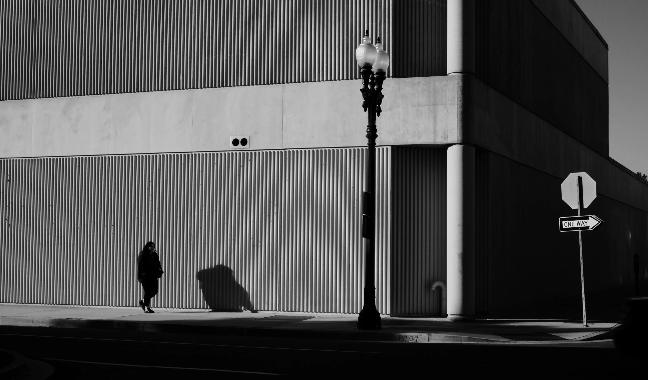 black and white po of people walking past tall building