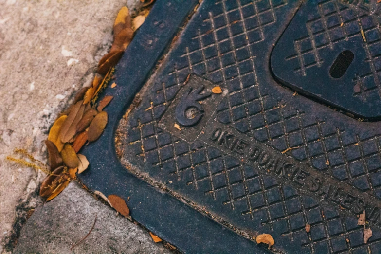 an old manhole is near the curb on which it stands