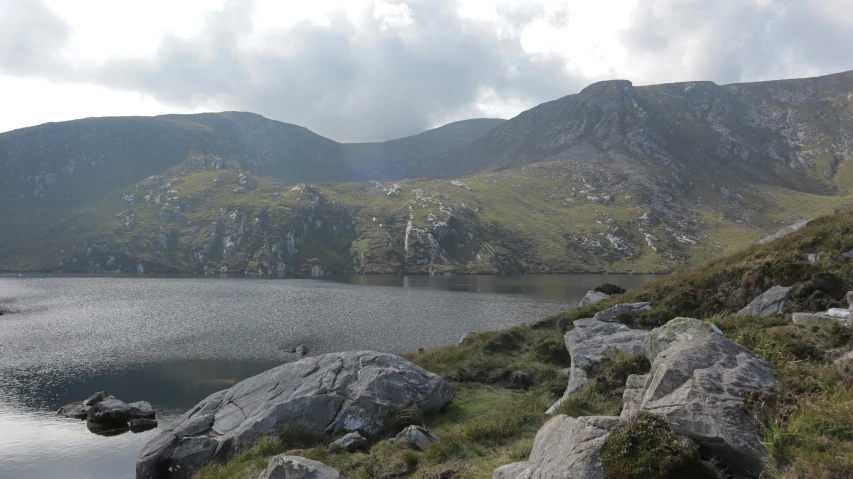 a mountain lake with rock covered banks near it