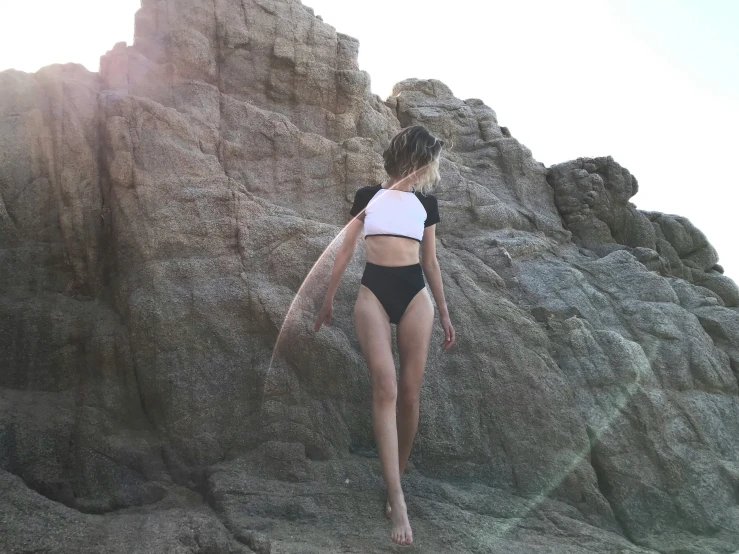 woman wearing black bathing suit walking into the water