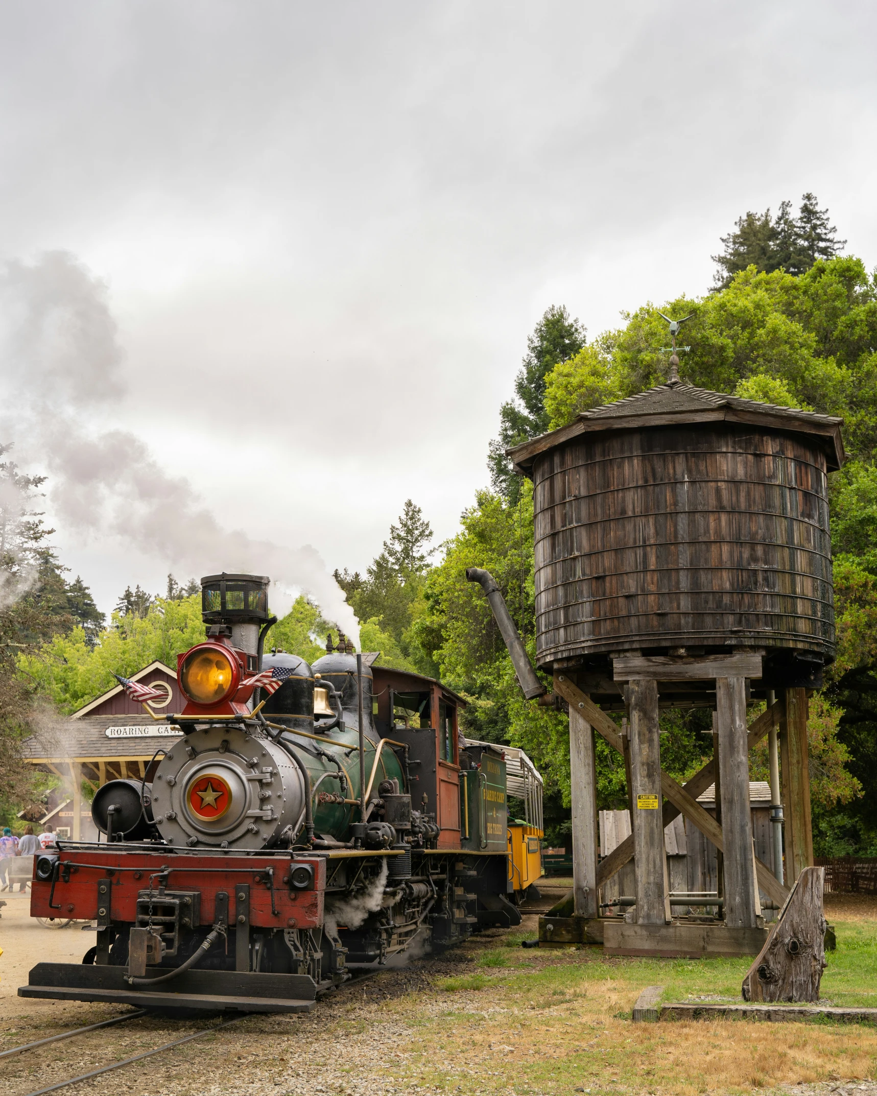 an antique train sits beside a large tower