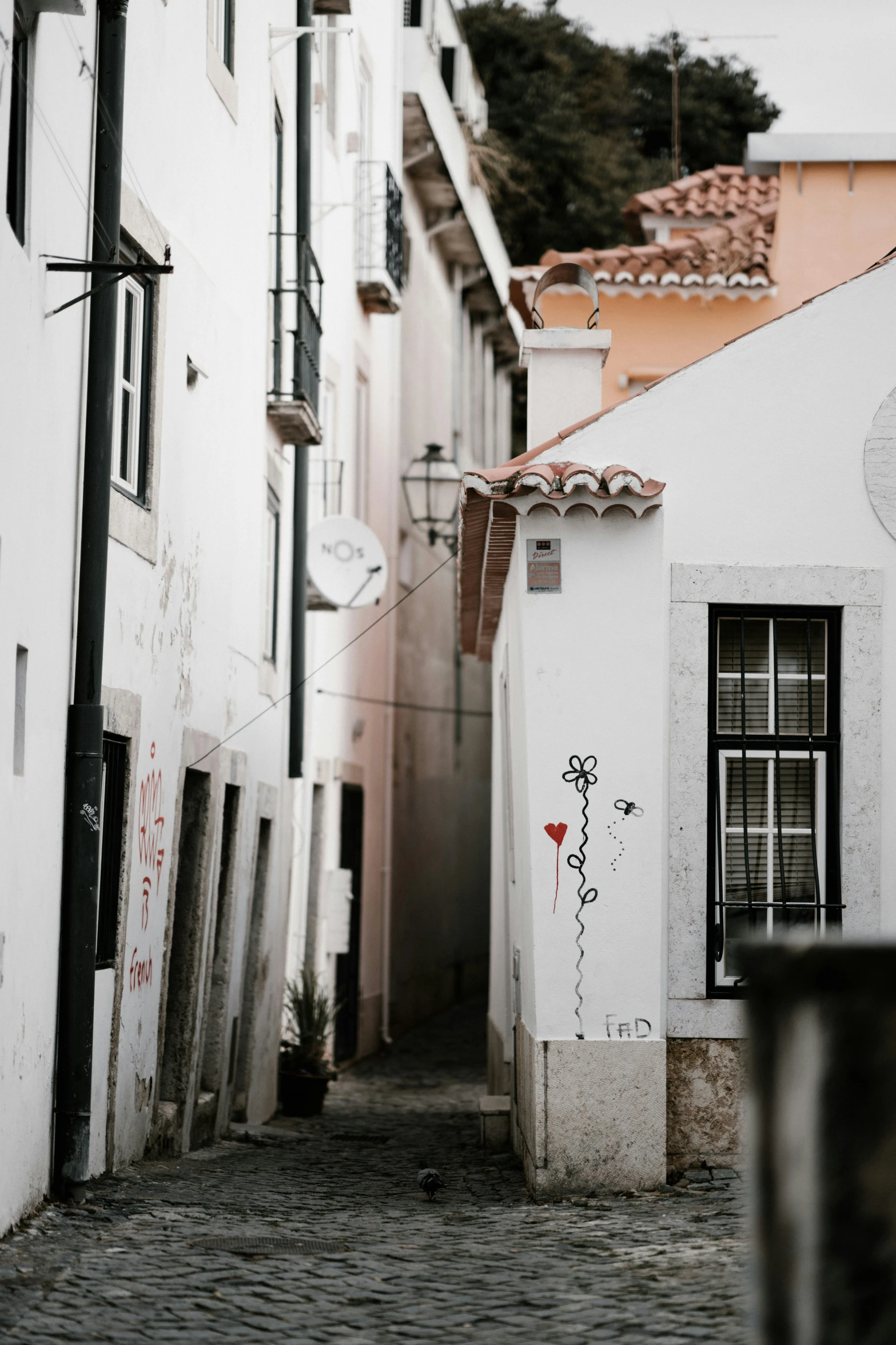 a narrow street leading into some buildings with graffiti