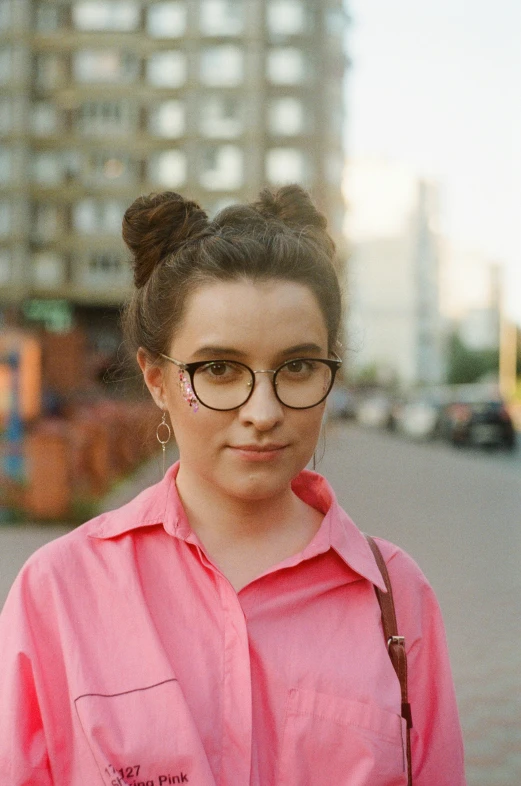 a young woman with glasses on a city street