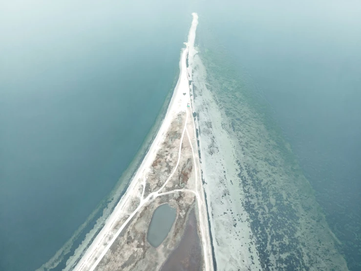 an aerial view of a long stretch of ice covered beach