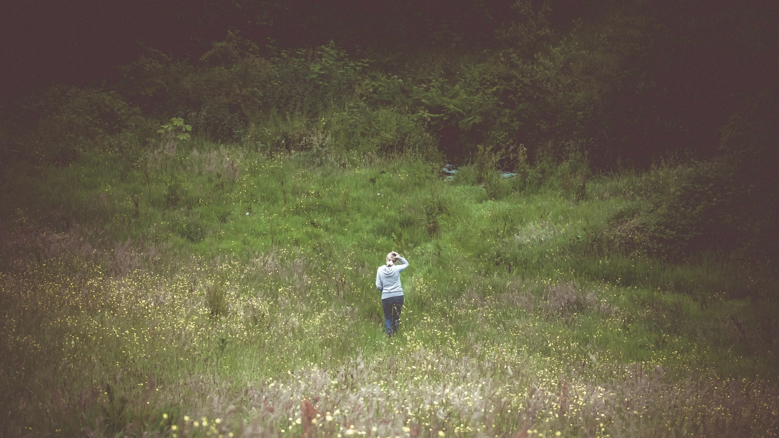 the woman in the field is waving to soing