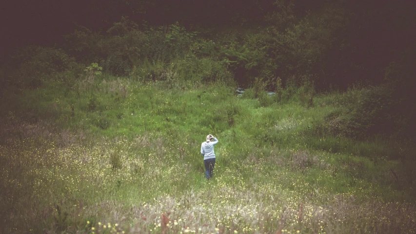 the woman in the field is waving to soing