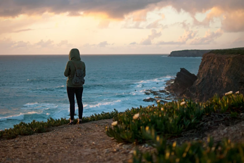 there is a person standing near a cliff