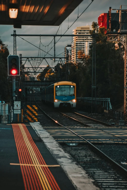 a train traveling past tall buildings near a train station