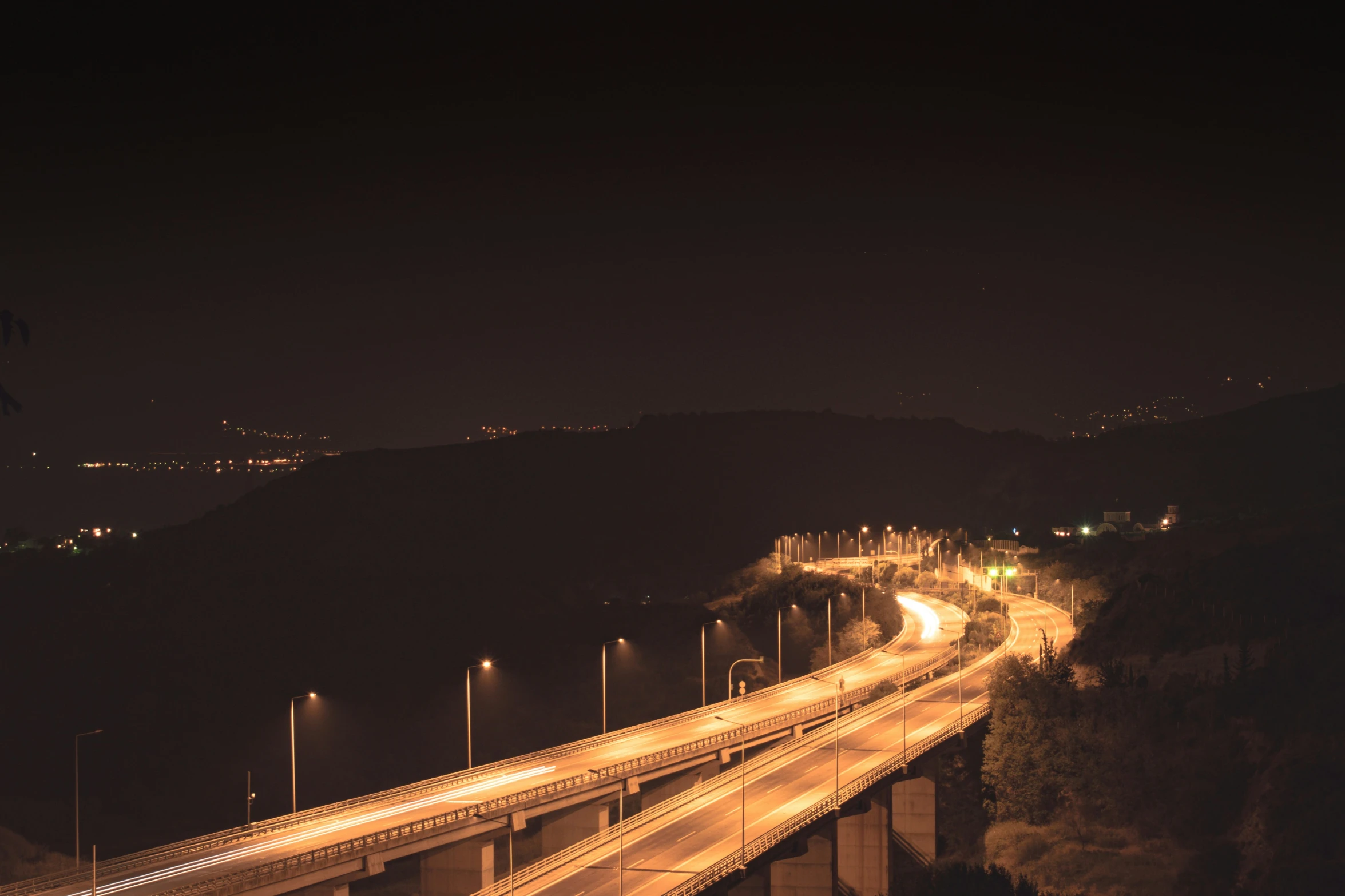 night view of a highway with a mountain backdrop