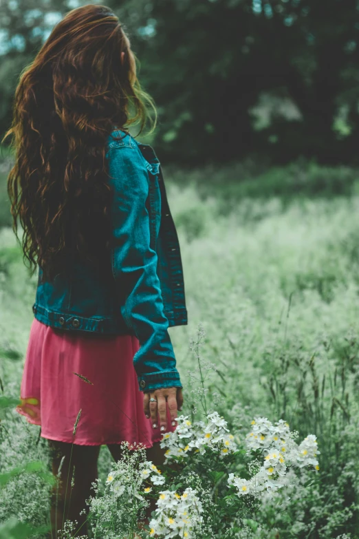 a girl in a pink skirt standing next to white flowers