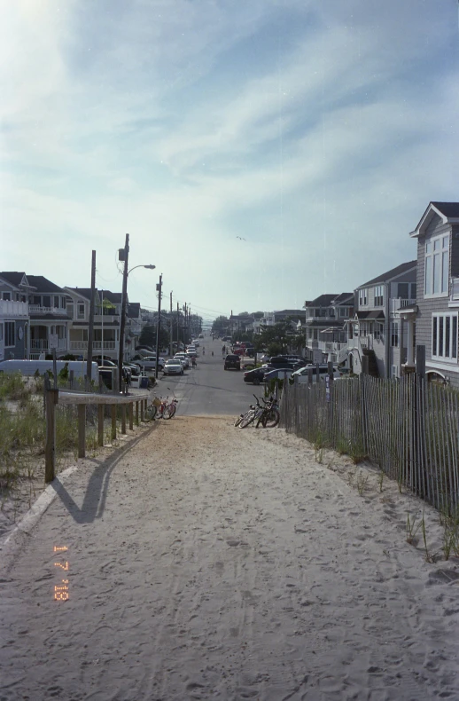 a small beach side town street with houses in the background