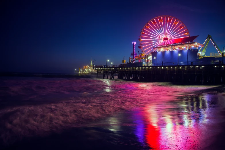 a colorful carnival wheel by the water