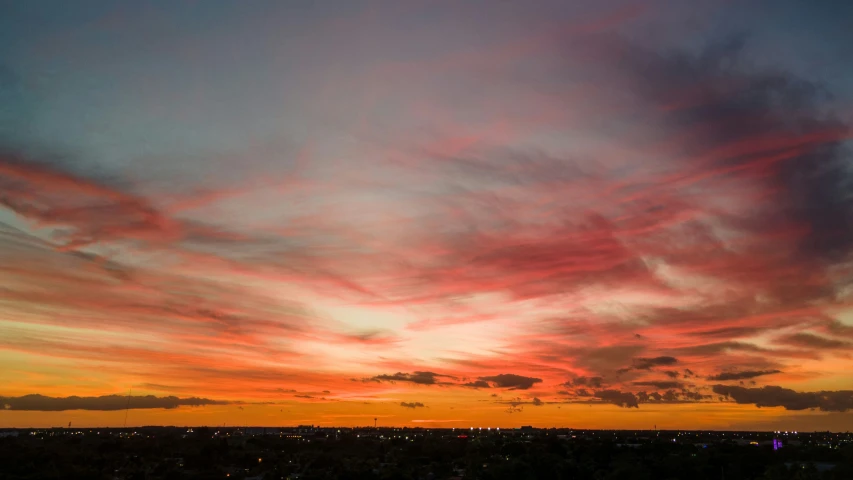 the sky is cloudy and colorful while the sun sets