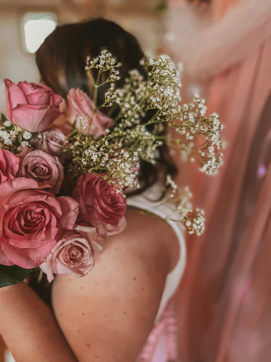 a woman holding a bunch of flowers on her back