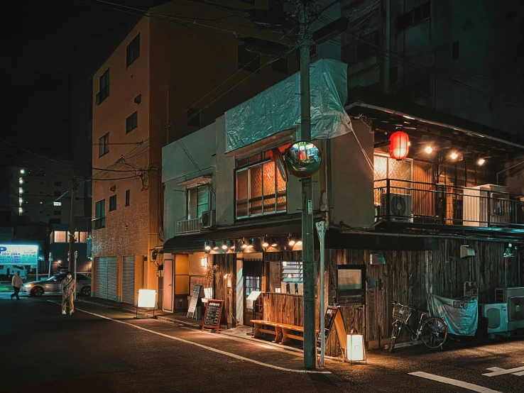 an outdoor cafe with many lit up tables and windows at night