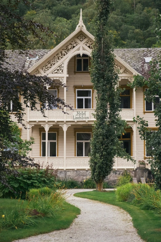 an older fashioned house with a sign on it and a pathway passing through the grass