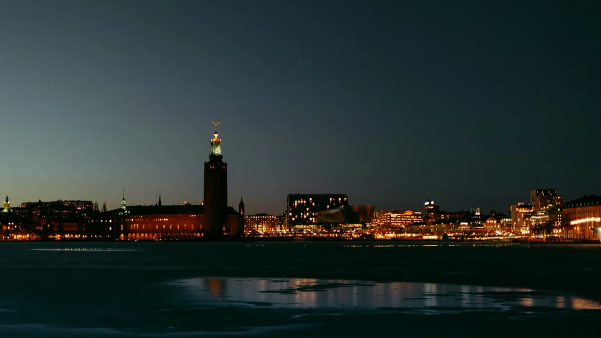 a city in the night with water and ice on the ground