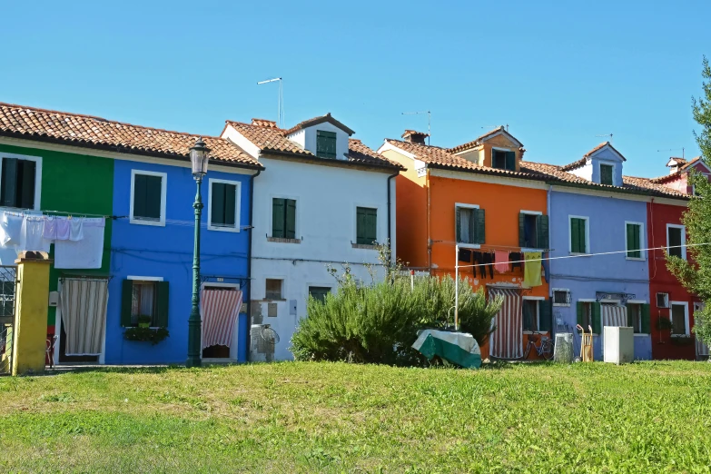 several multi - colored houses next to each other on grass