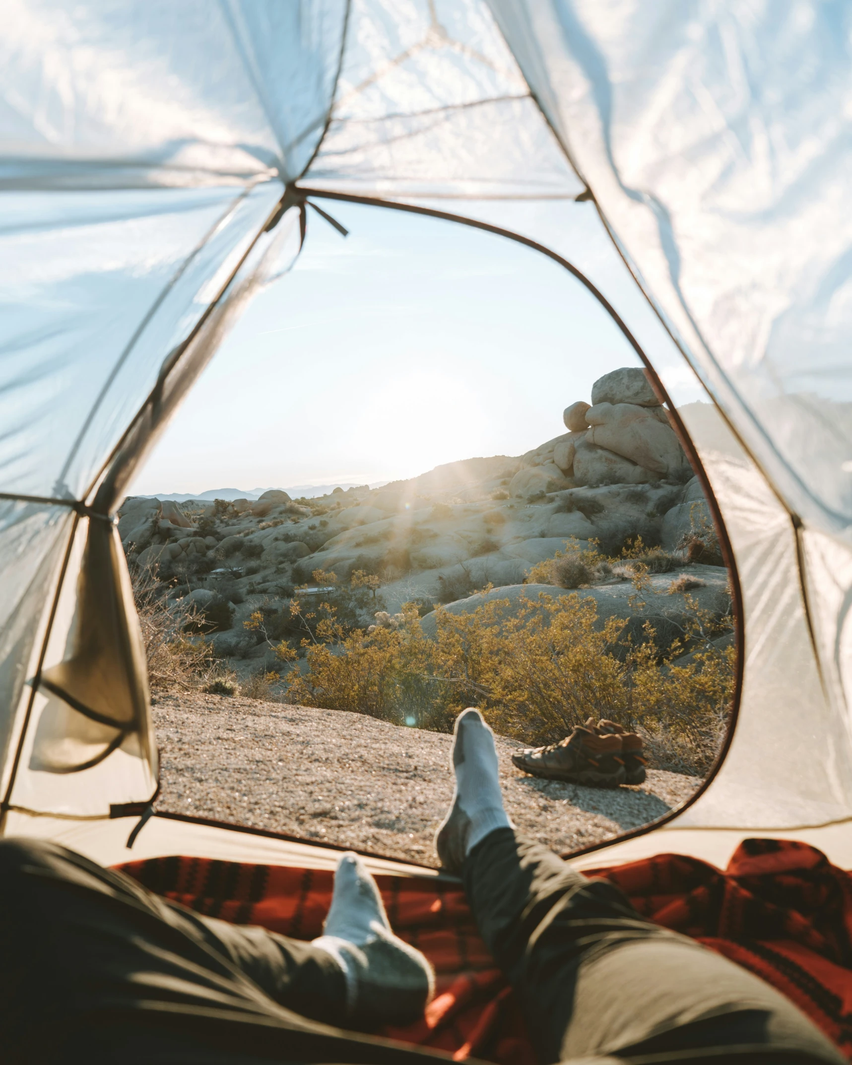 a person with their legs up and their feet out of a tent