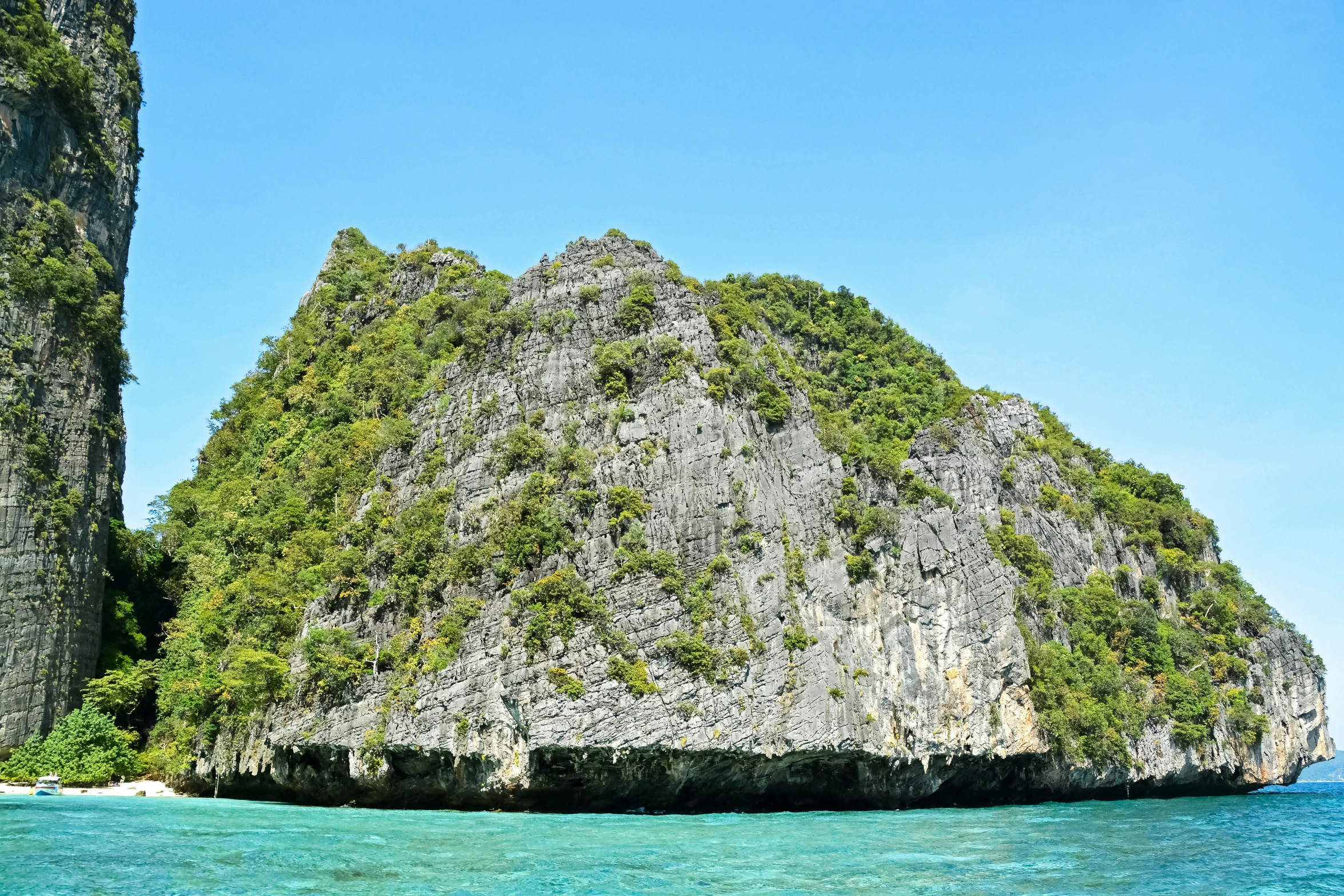 a boat traveling along the shore near two island