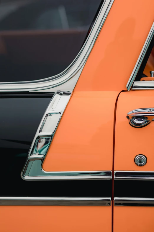 an orange car showing the hood ornament and emblem