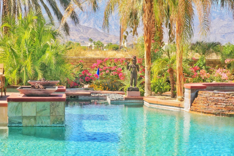 the pool and spa are surrounded by tropical greenery