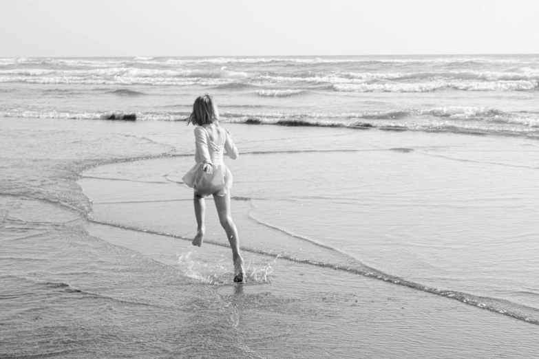 the lady is holding a frisbee in one hand and her other hand is in the water