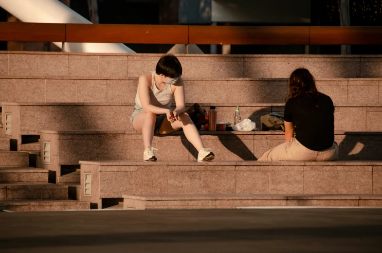 the two girls are sitting on the stone benches