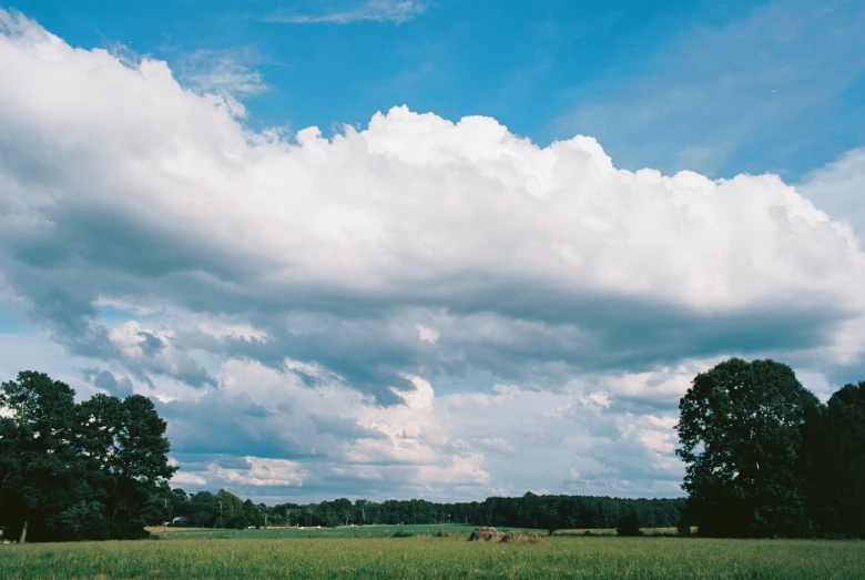 an empty field under a cloudy blue sky