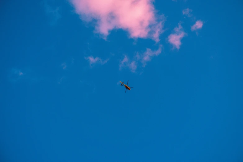 a jet flying thru a blue sky with some white clouds