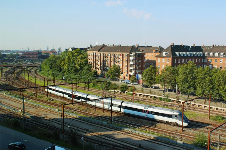 an aerial view of a long silver and white train on the tracks