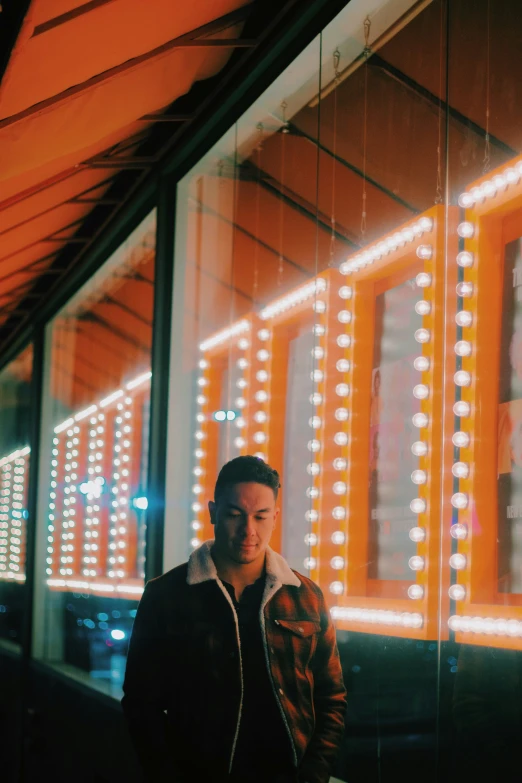 a man is standing outside a building with lights