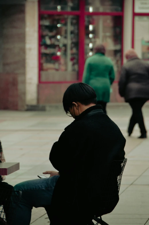 a man is sitting in a chair using his phone