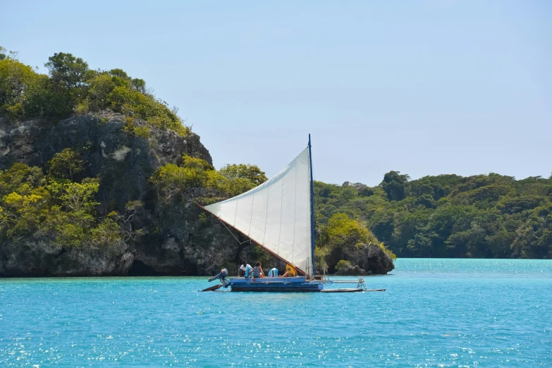 a large white sail boat floating in the middle of the ocean