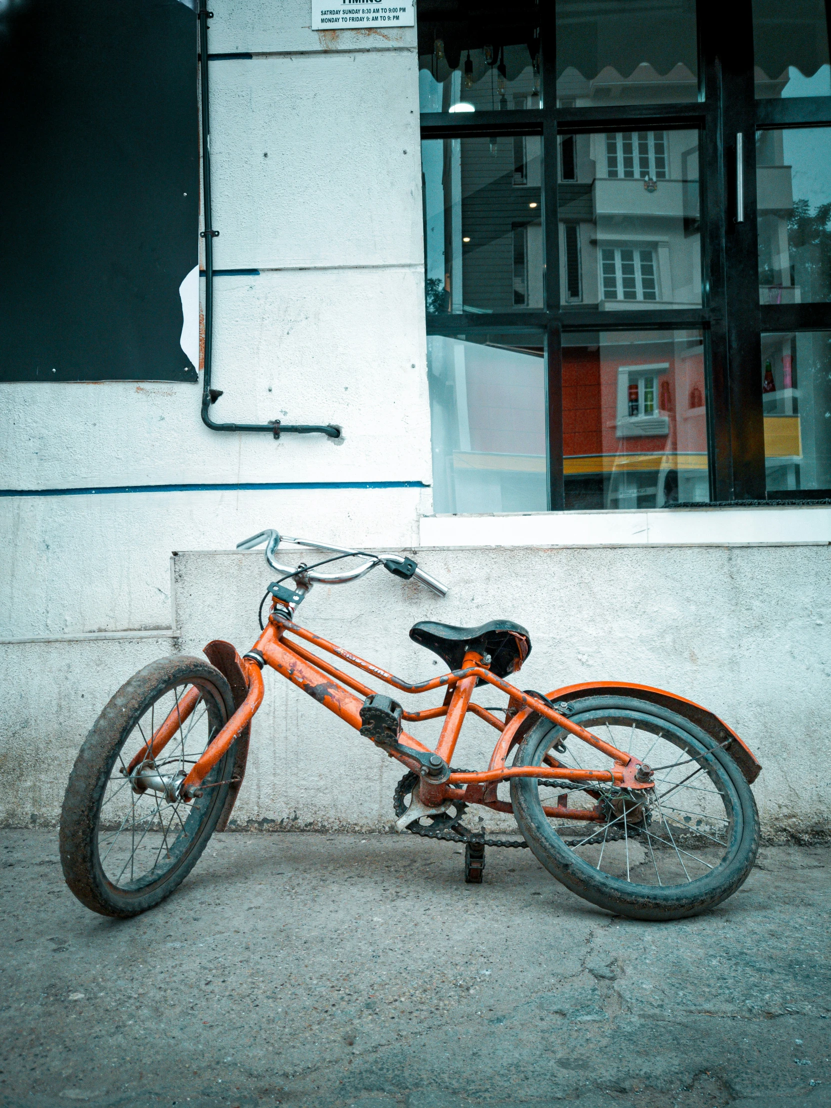 a bicycle parked outside of a building with a brick wall