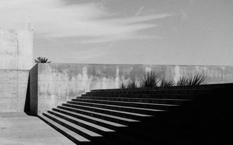 a black and white image of a stair case and a concrete wall