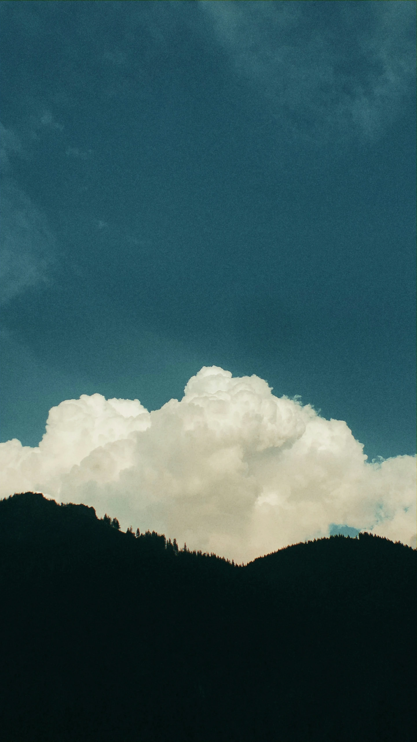 a dark colored sky and a group of mountain ranges