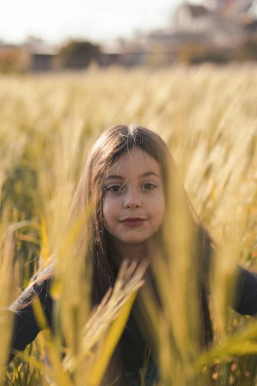 a little girl is sitting in a field